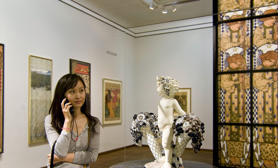 A girl listening to an audio guide at the exhibition "Vienna 1900: Klimt — Moser — Gerstl — Kokoshka A girl listening to an audio guide at the exhibition "Vienna 1900: Klimt — Moser — Gerstl — Kokoshka